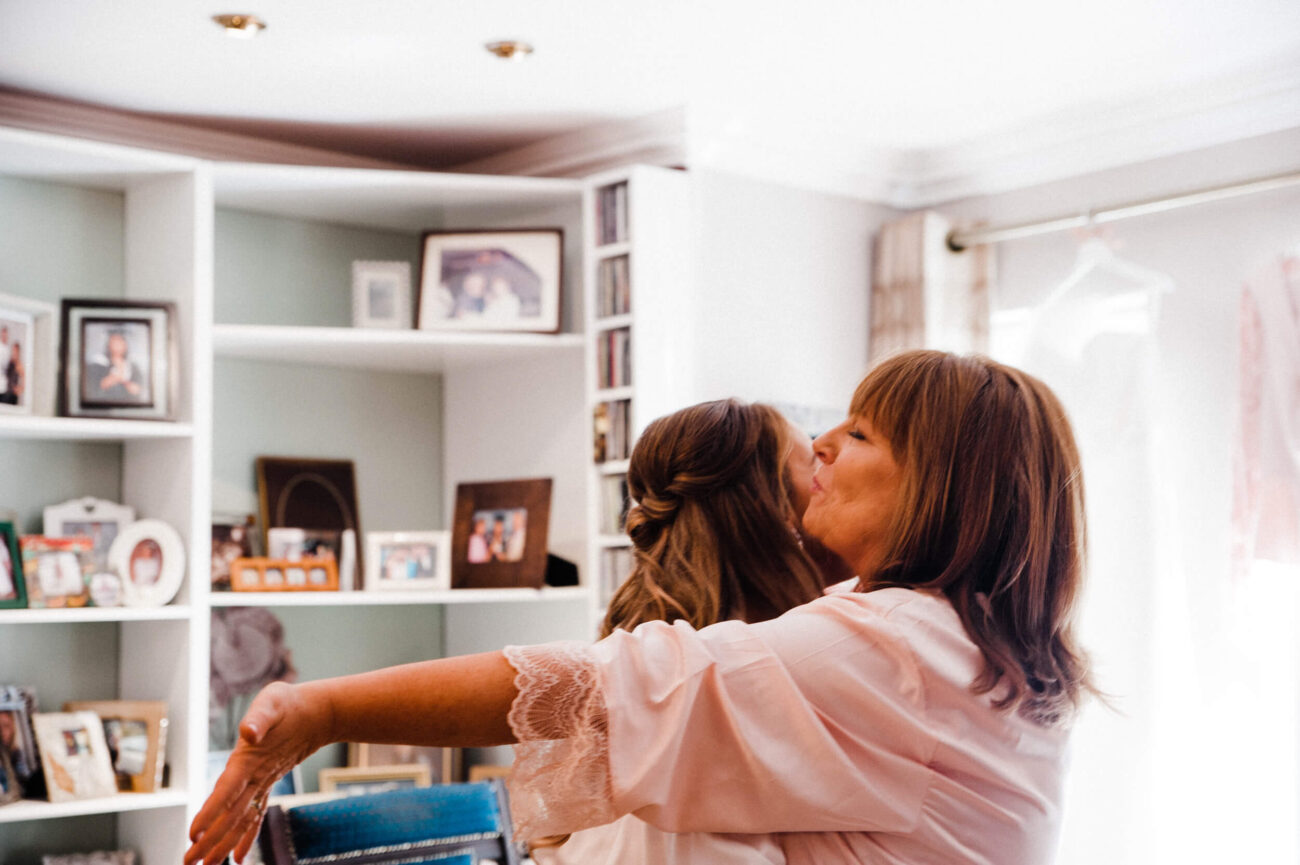 Bride kissing her mother at bridal prep