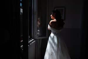 bride fixing her earing next to the window in The Clarence Hotel