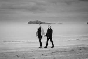 couple walking holding hands at Portmarnock beach