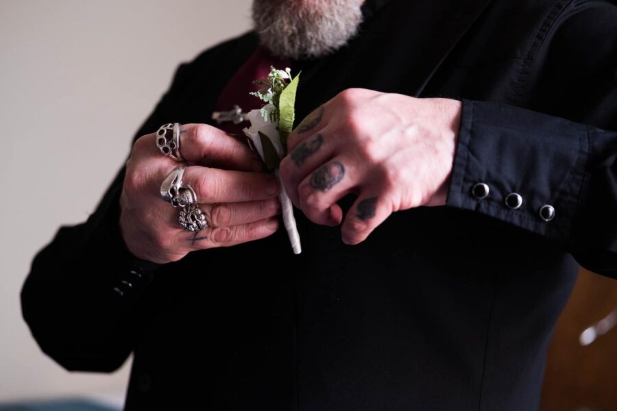 Groomsman portrait, close up of groomsman fixing his flowers