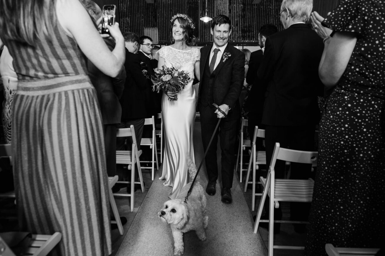 Bride, groom and dog walking down the aisle in Cloughjordan House