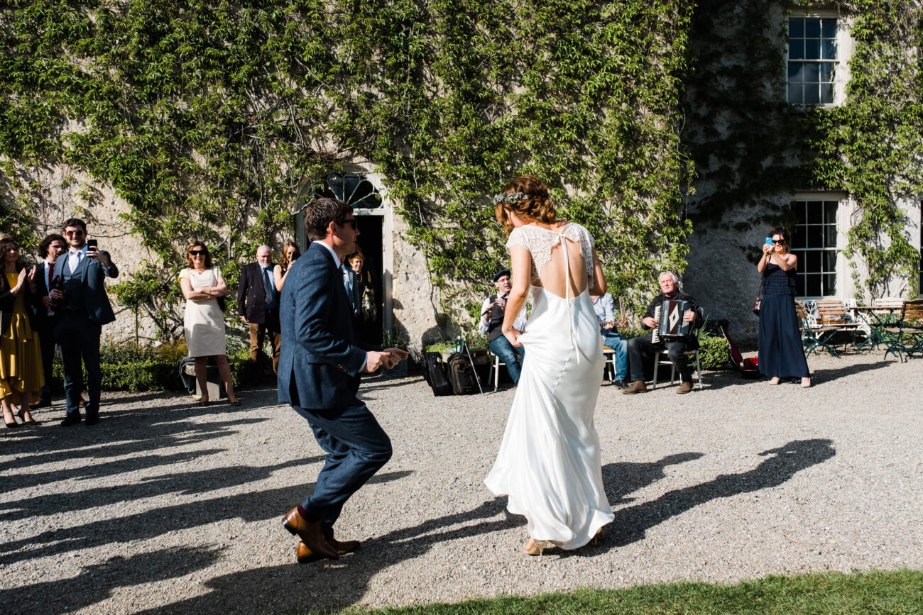 Bride dancing with groom in the courtyard at the front of Cloughjordan House