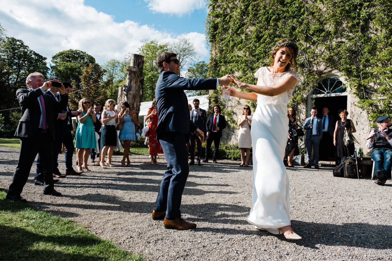 Bride dancing with groom in the courtyard at the front of Cloughjordan House, candid wedding photography