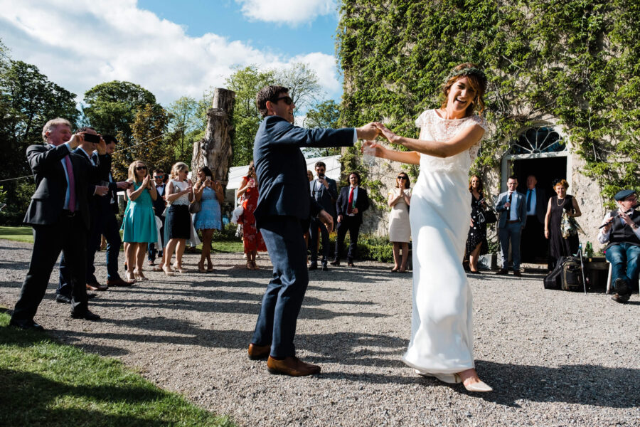 Bride dancing with groom in the courtyard at the front of Cloughjordan House