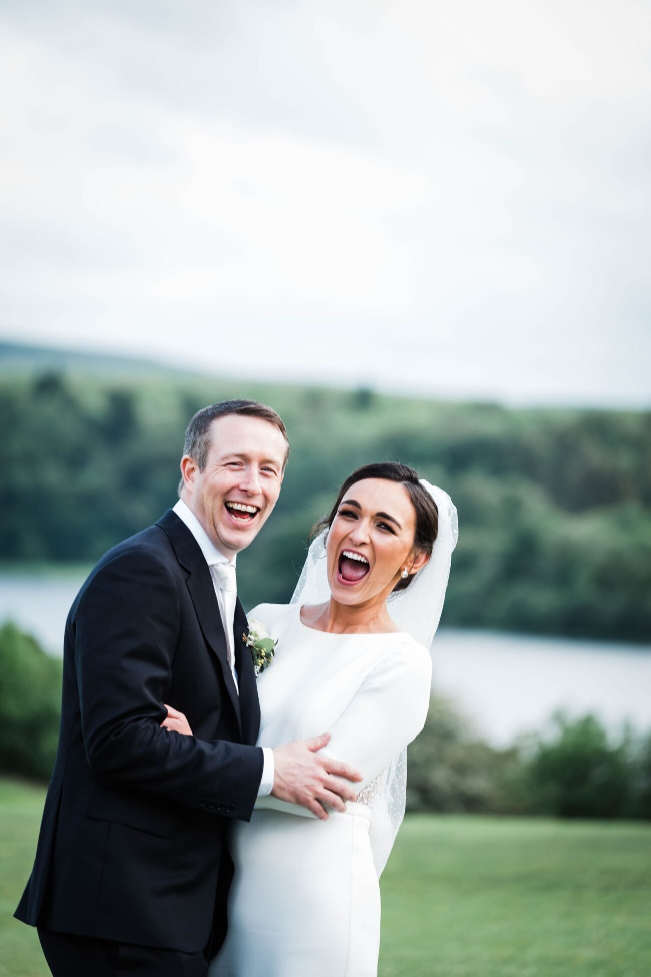 Bride and groom arm in arm laughing at the camera at Kilronan Castle