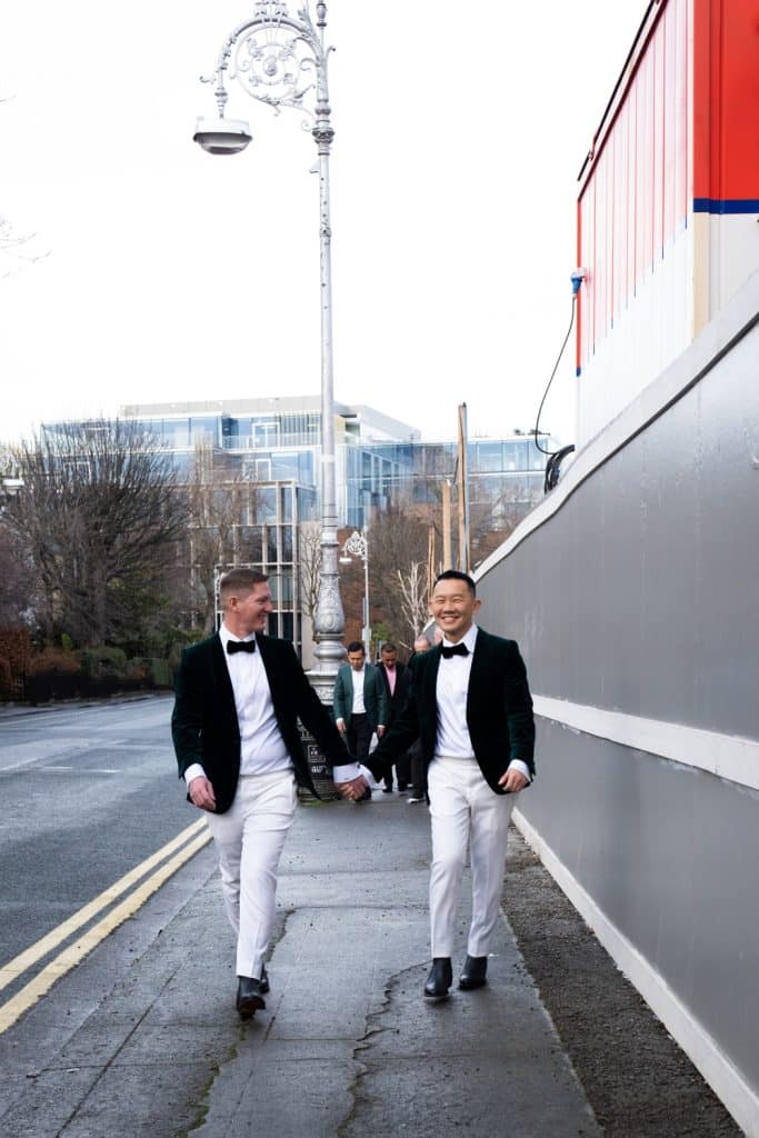 Grooms walking, holding hands and laughing