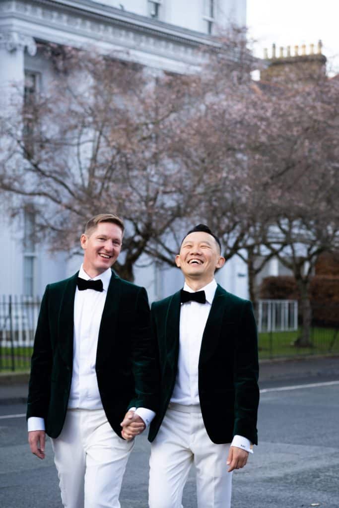 Grooms walking, holding hands and laughing