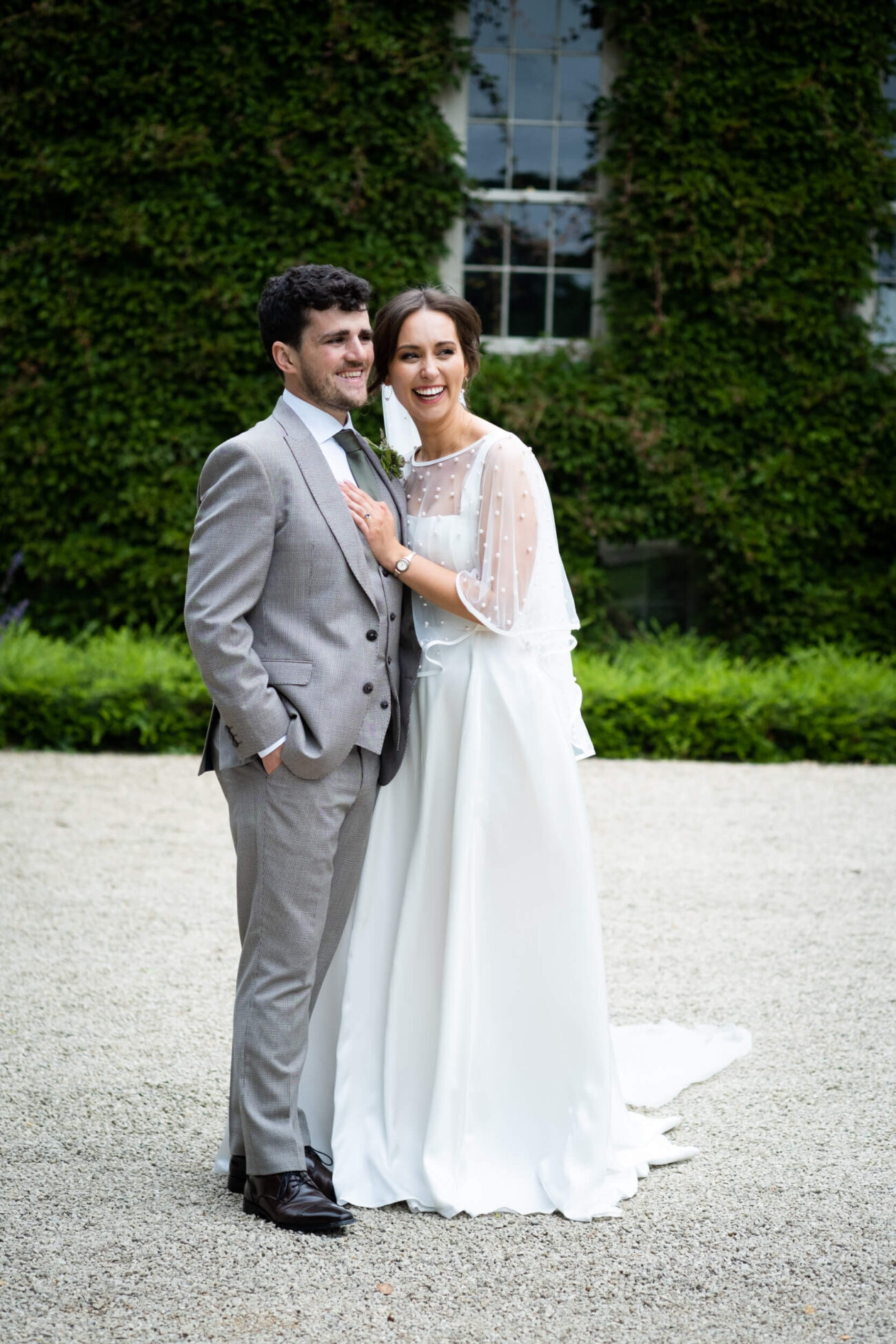 Bride and groom laughing together at the front of the house at Ballintubbert Gardens and House