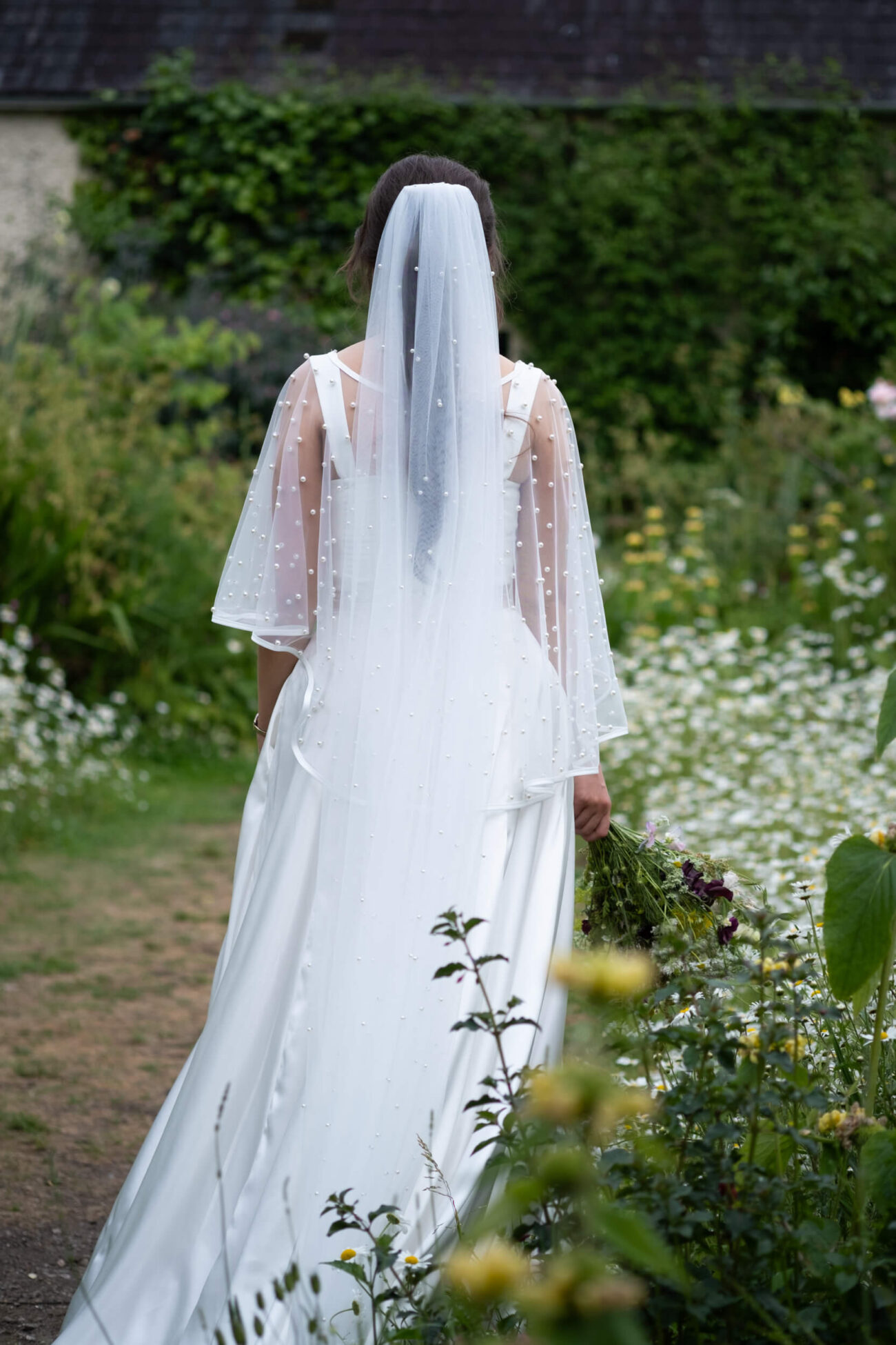 Back of bride walking in the flower garden of Ballintubbert Gardens and House