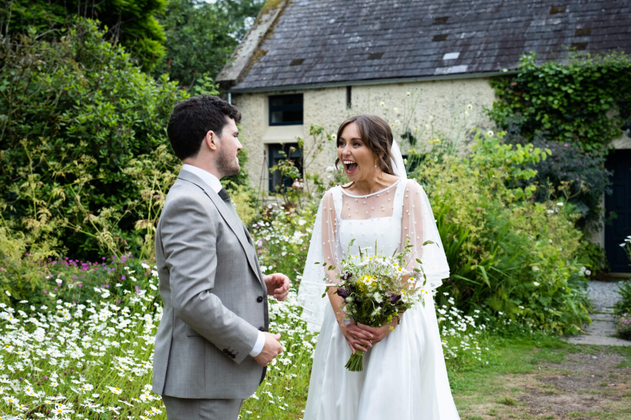 bride and groom laughing in surprise and smiling in the flower garden of Ballintubbert Gardens and House