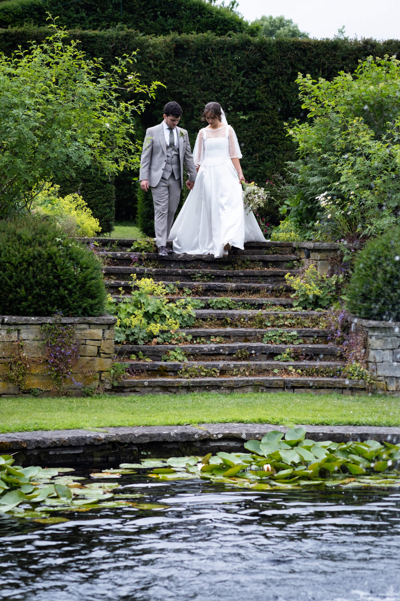 Bride and groom walking hand in hand down the steps of The Fountain Garden of Ballintubbert Gardens and House