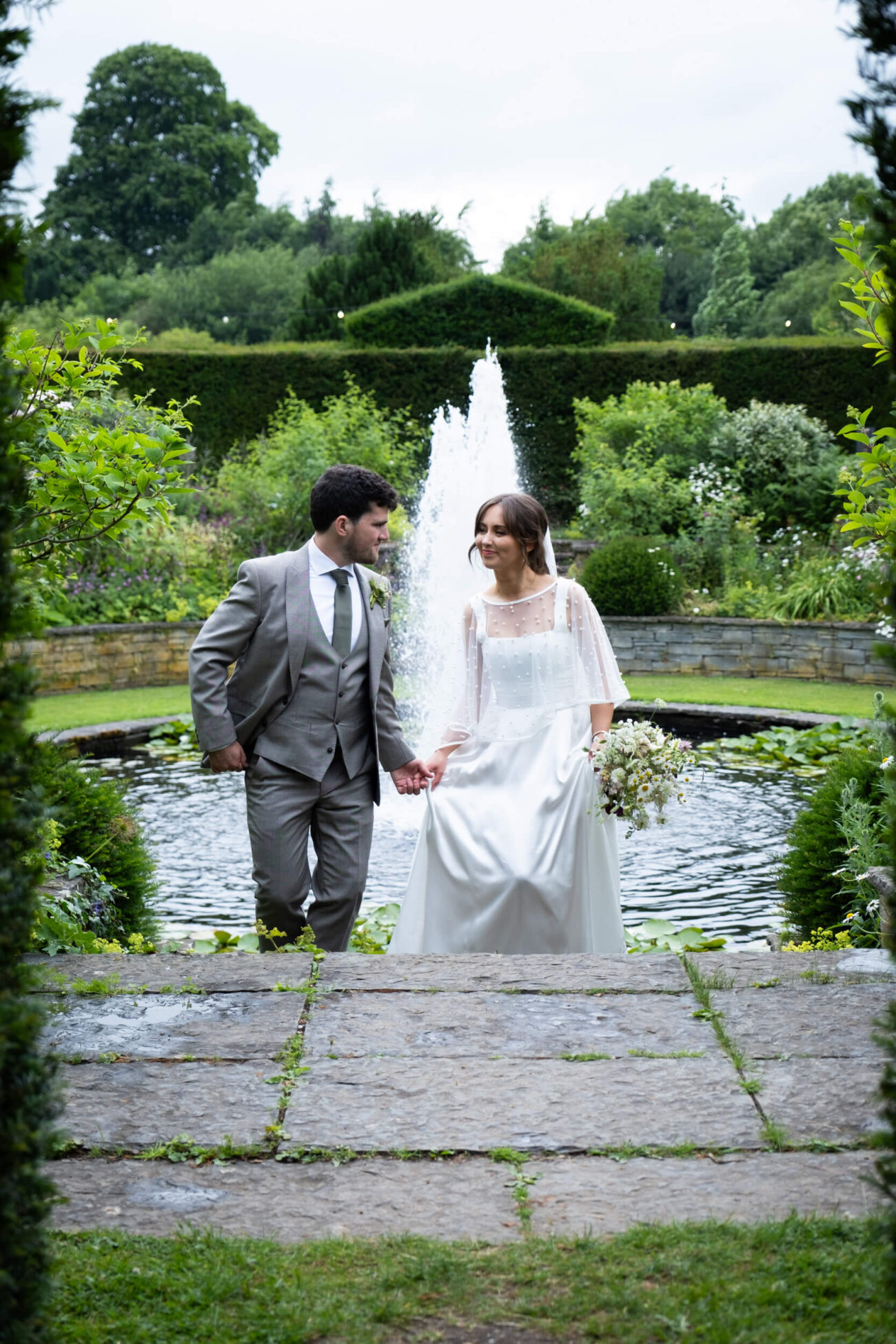 Bride and groom walking hand in hand up the steps of The Fountain Garden of Ballintubbert Gardens and House