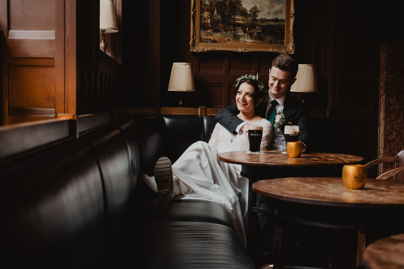 Wedding at The Clarence Hotel, bride and groom sitting in The Oak Bar