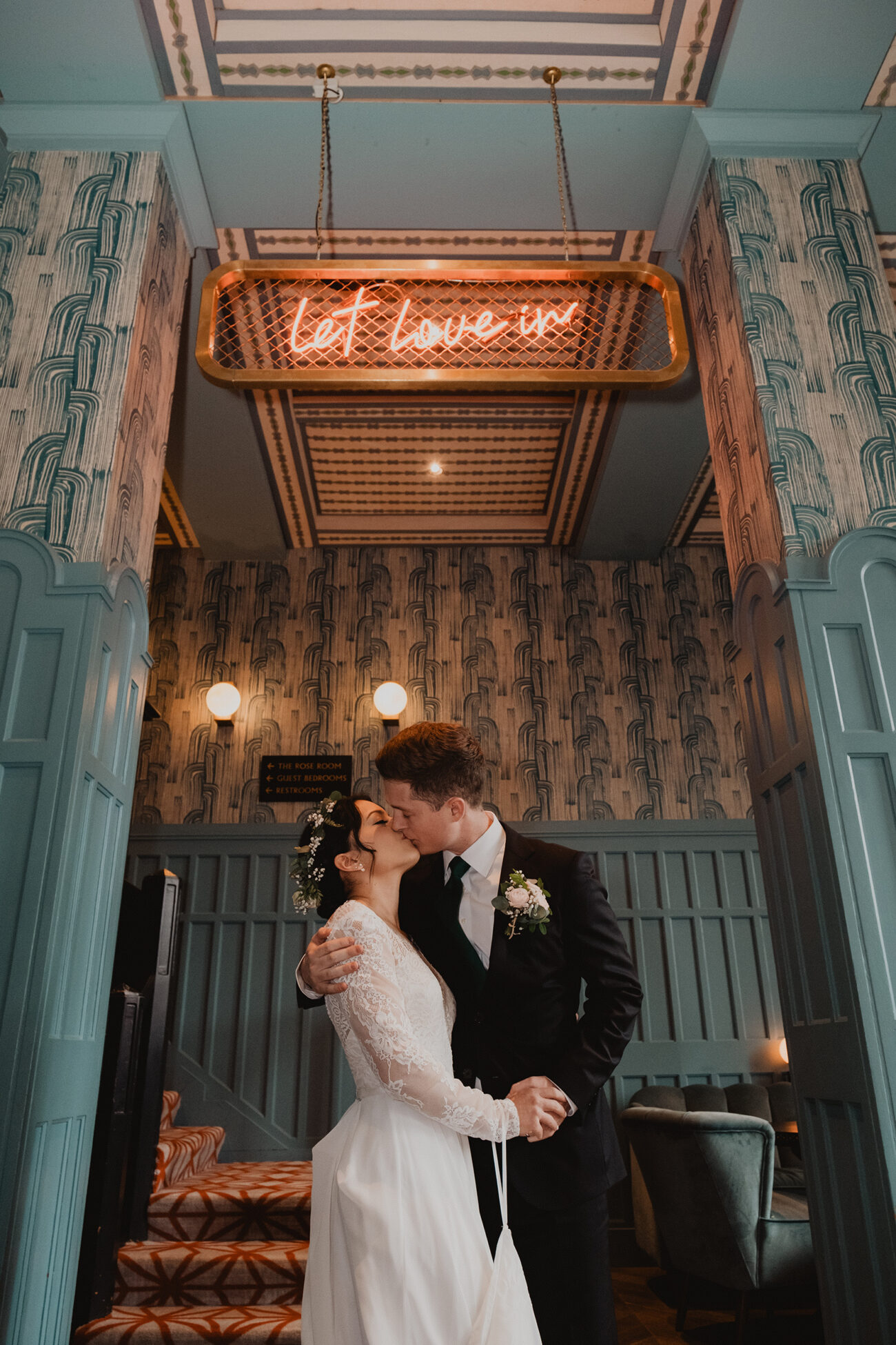 couple kissing under the Let Love in sign at The Clarence Hotel, Clarence Hotel wedding