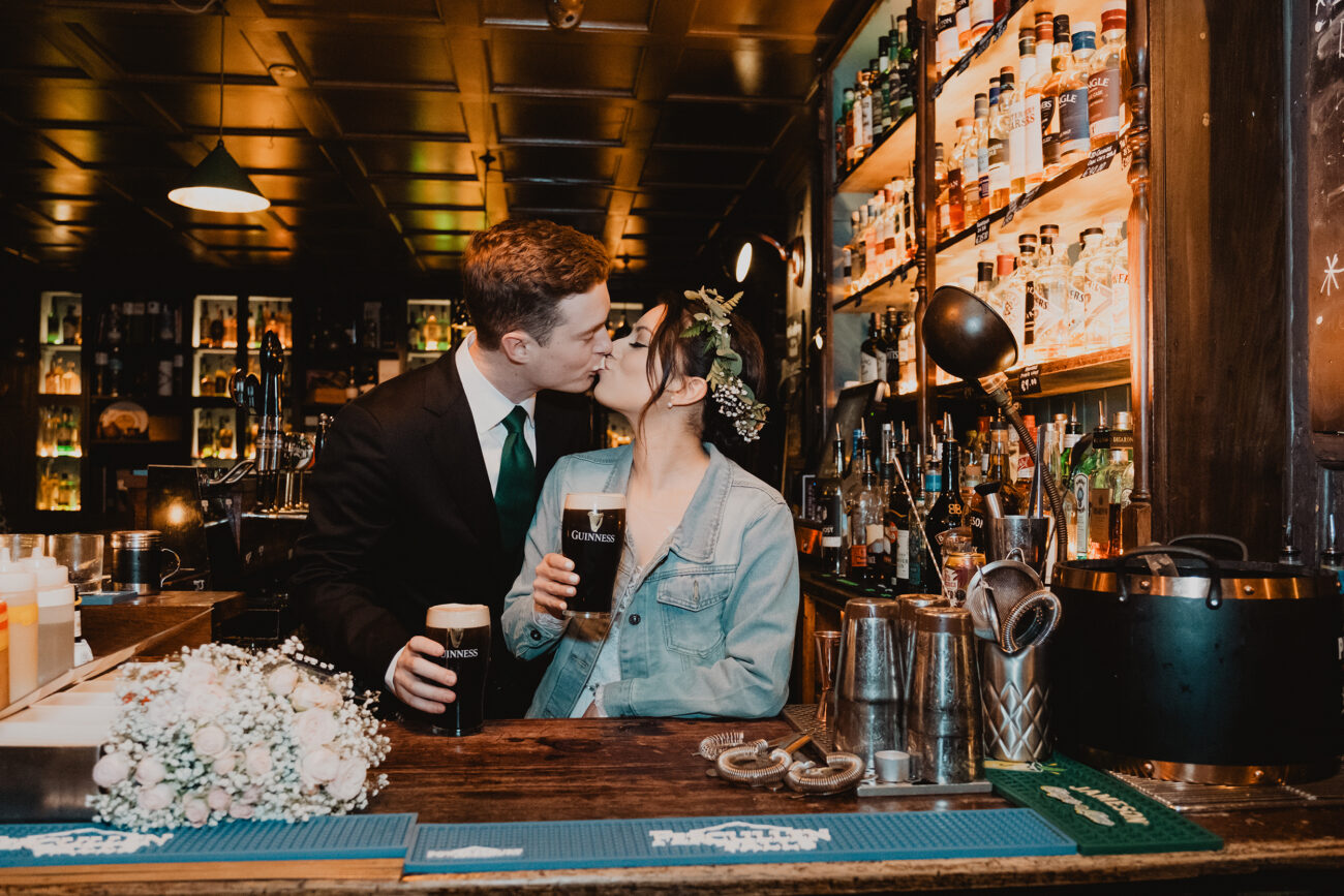 Couple pouring and drinking a pint behind the bar at The Rag Trader Pub, Dublin City Wedding, elopement in Dublin