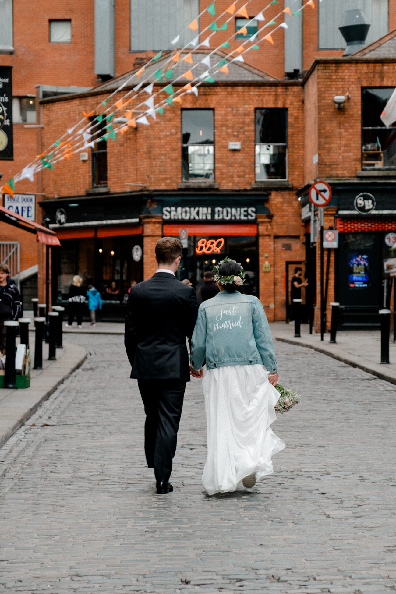 couple walking and holding hands in the street in Temple Bar. Dublin elopement