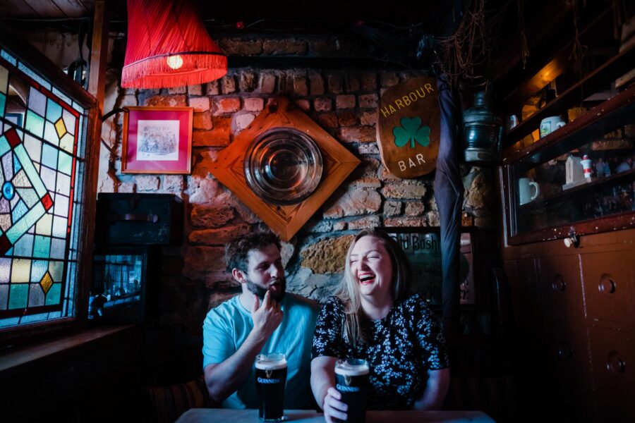 Couple drinking Guinness and laughing in The Harbour Bar Bray