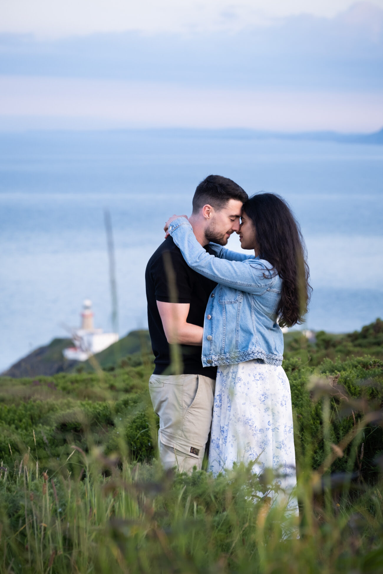 couple hugging at Howth Summit with the lighthouse in the background