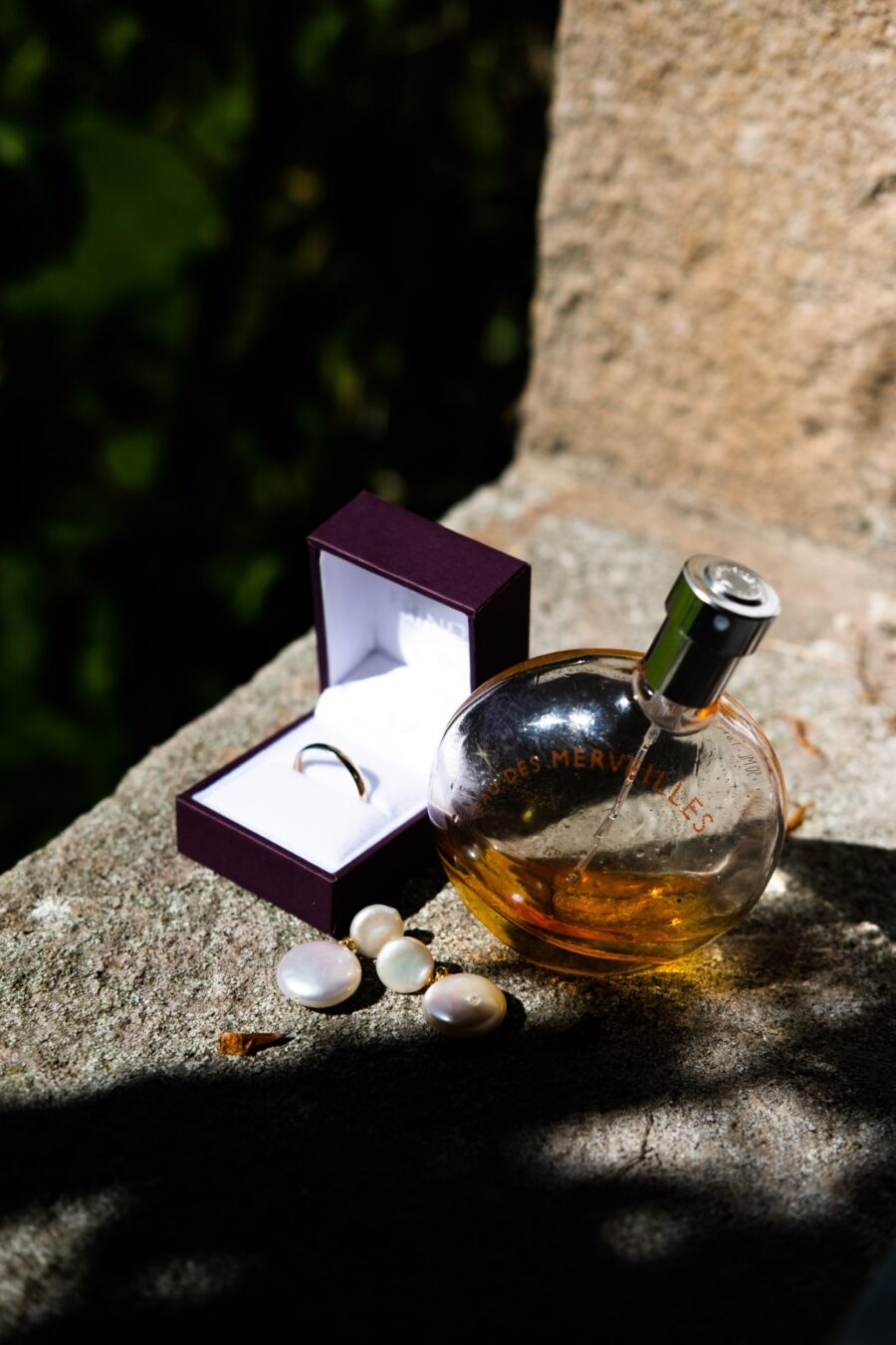 Still life of brides jewellery and perfume at Roundwood House stone wall