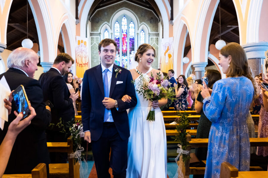 Couple walking down the aisle together after the ceremony