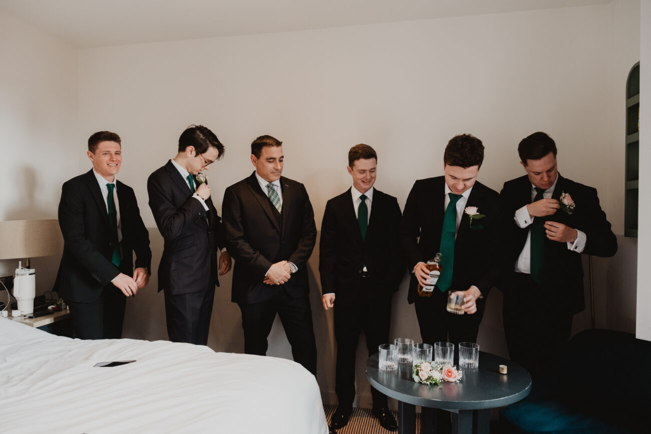 Groomsmen putting flowers on suits at The Clarence Hotel