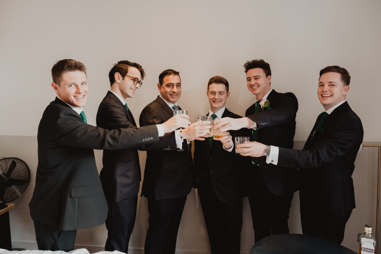 Groomsmen toasting whiskey at The Clarence Hotel, wedding at The Clarence Hotel