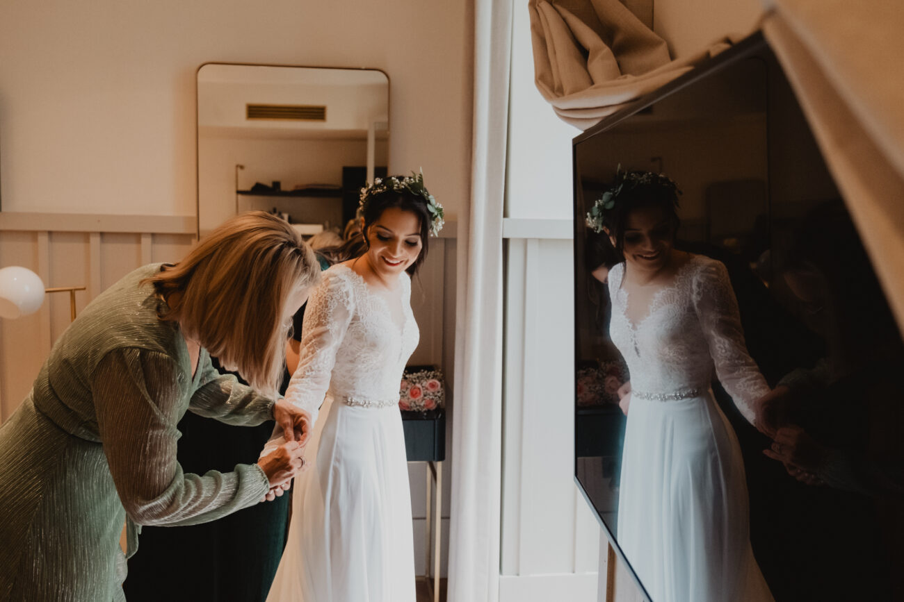 Bridal party adjusting brides dress during bridal prep at The Clarence Hotel, wedding at The Clarence Hotel, elopement in Dublin 