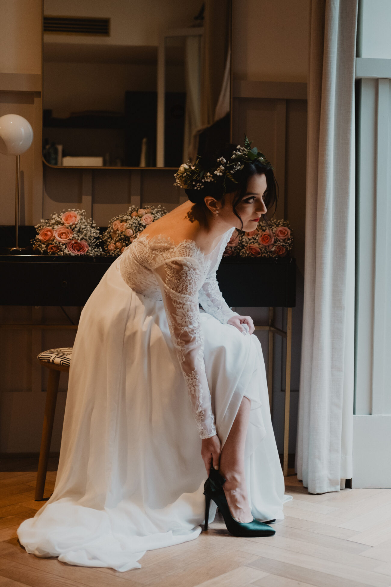 Bride putting her shoes on and looking out the window at The Clarence Hotel, wedding at The Clarence Hotel, Elopement in Dublin