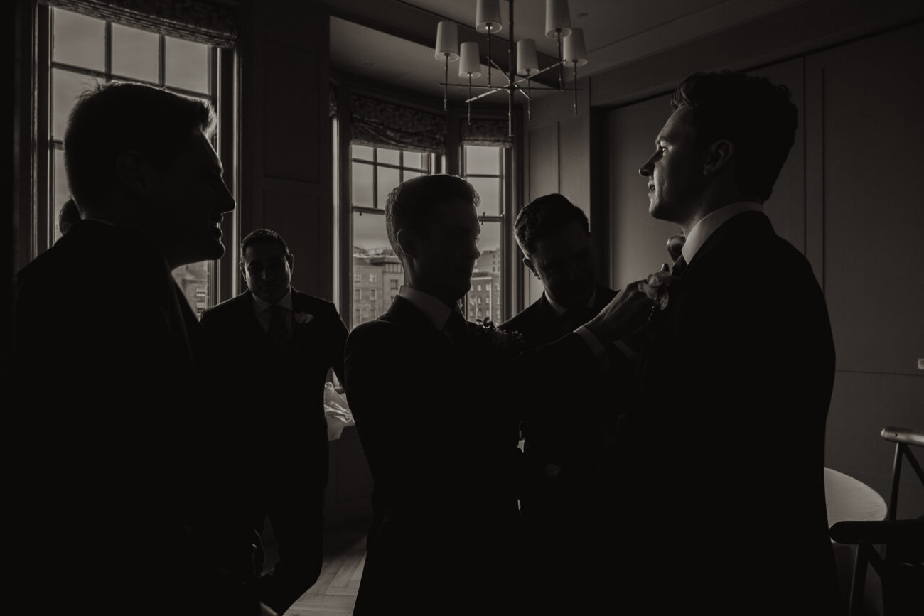 Groomsmen before the ceremony fixing ties at The Clarence Hotel