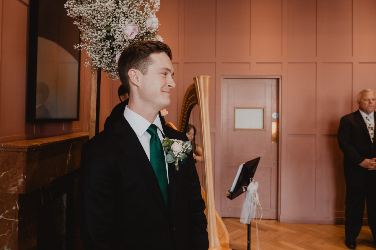 groom looking at his bride walking down the aisle at The Clarence Hotel