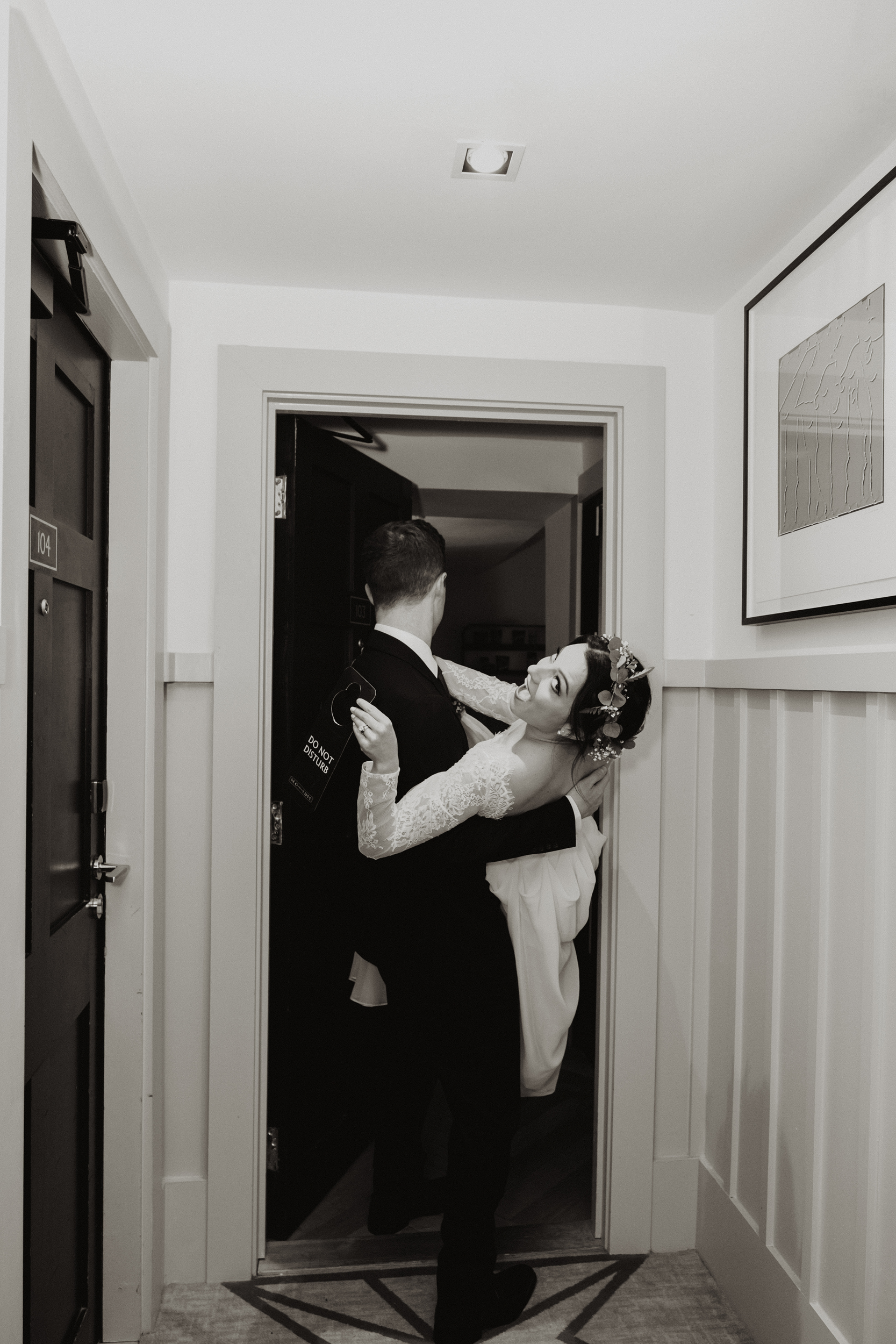 Bride and groom going into the bedroom with do not disturb sign, wedding at The Clarence Hotel