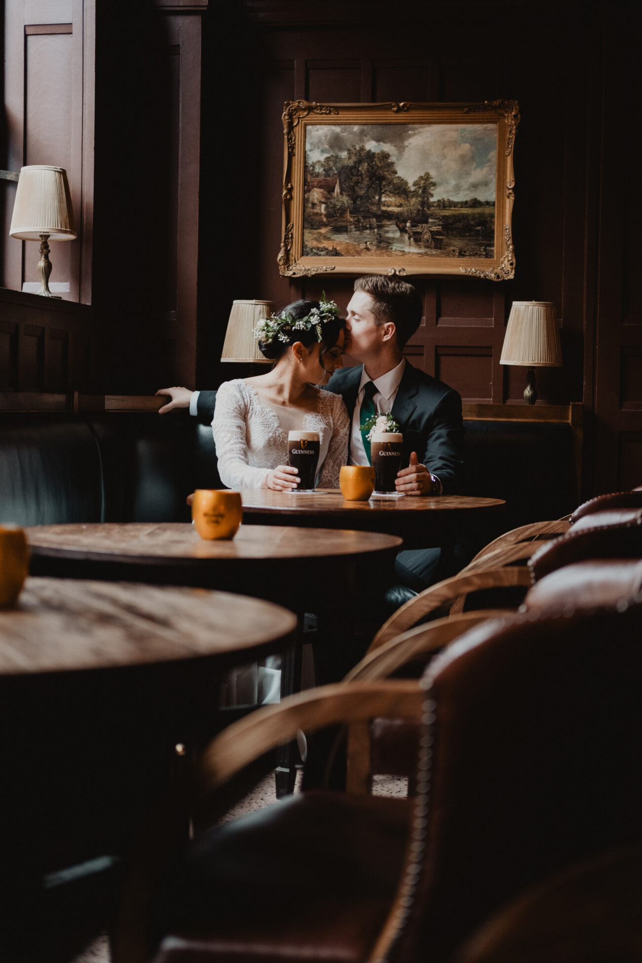 Bride and groom embracing with a drink at The Oak Bar in The Clarence Hotel, wedding at The Clarence Hotel