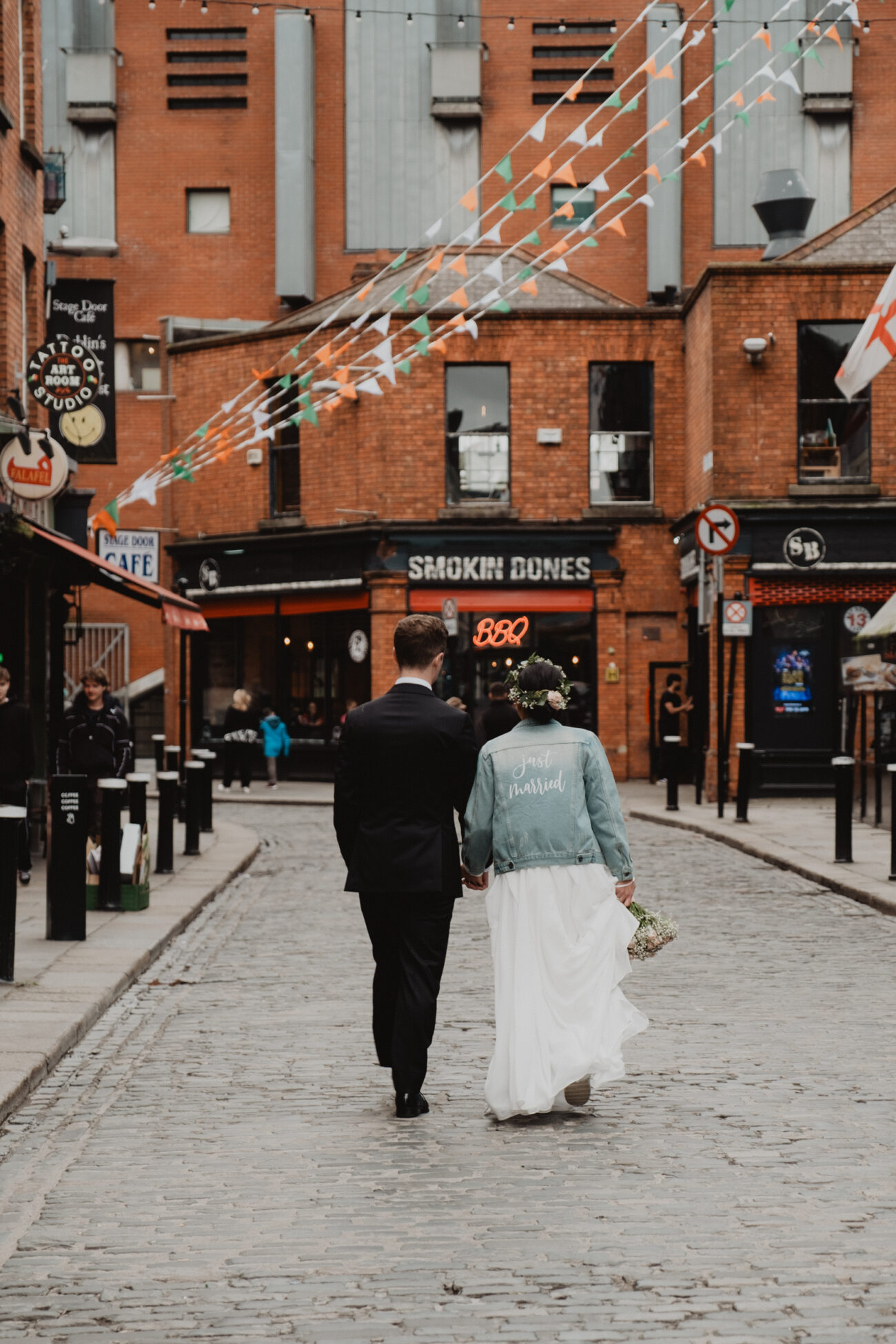 Bride and groom walking down the streets of Temple Bar, wedding at The Clarence Hotel, Dublin City wedding, Elopement in Dublin city