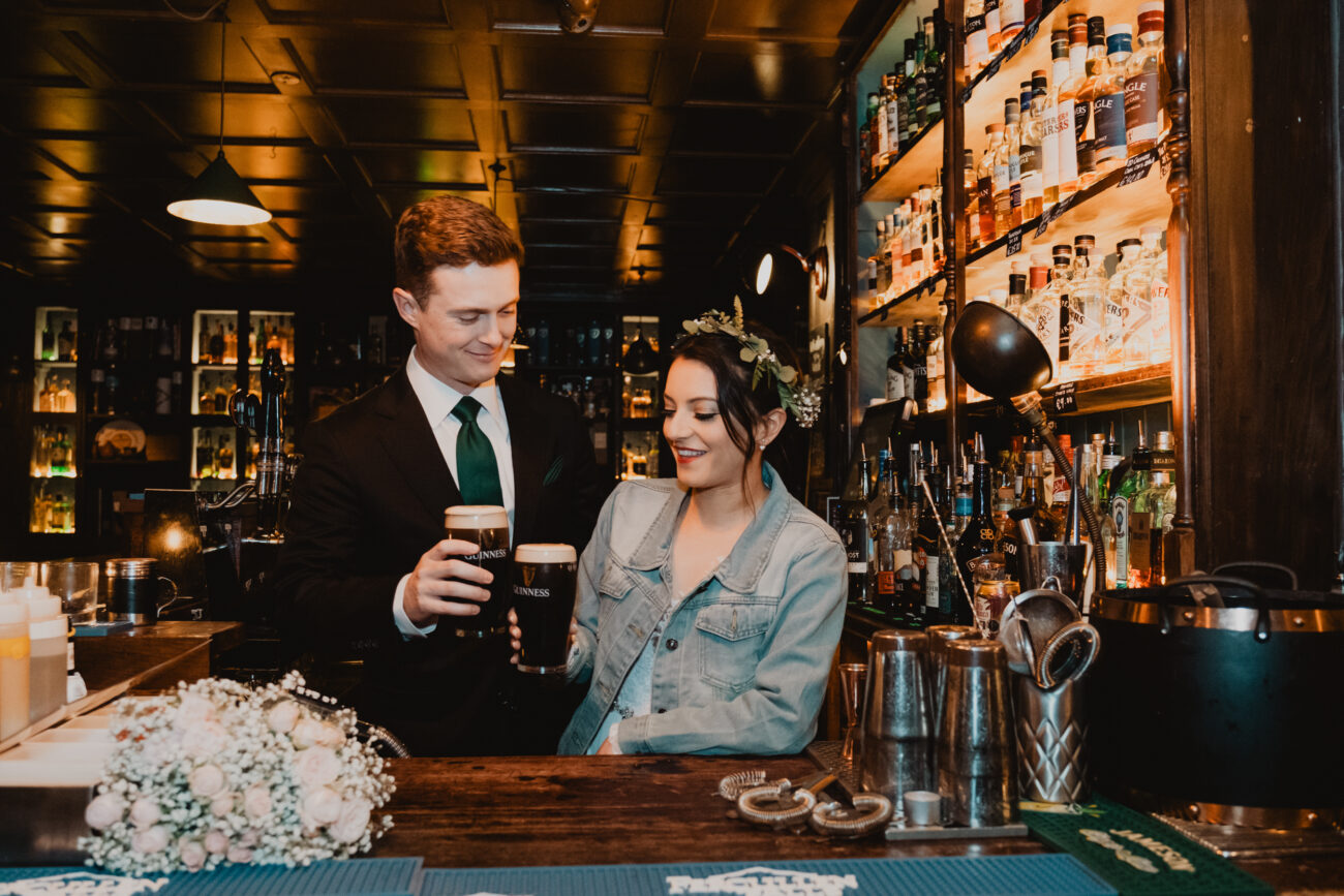 Couple pouring and drinking a pint behind the bar at The Rag Trader Pub, Dublin City Wedding, elopement in Dublin