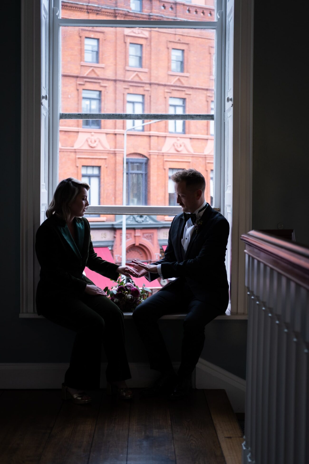 Bride and groom looking their rings at the window at no 5 South Leinster street at their wedding at The National Gallery of Ireland