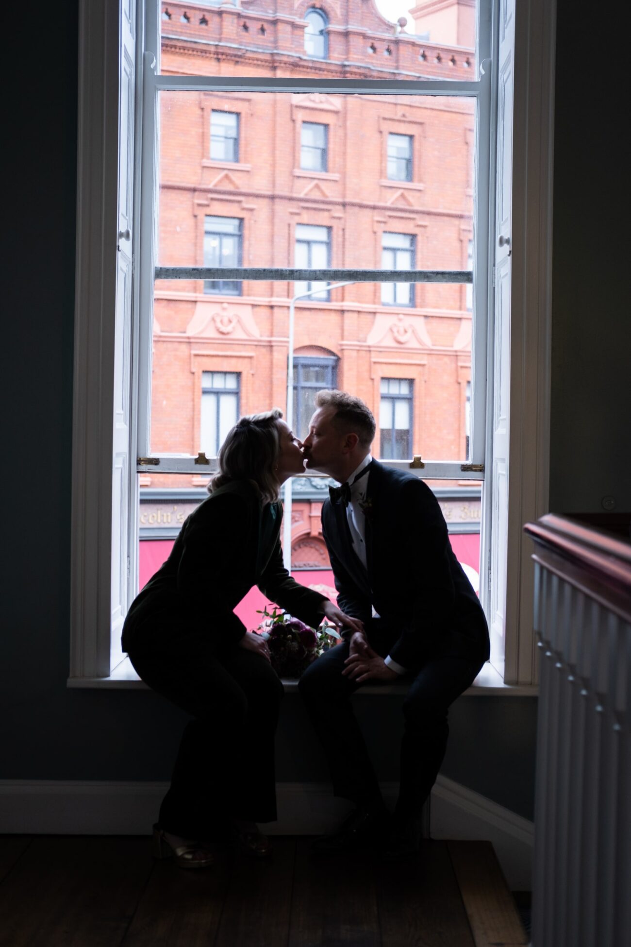 bride and groom kissing at the window at no 5 South Leinster street at their wedding at The National Gallery of Ireland