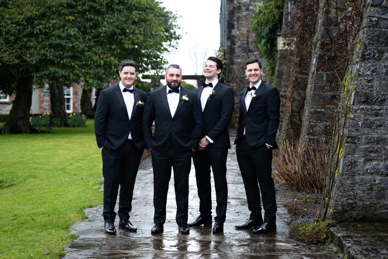 Groomsmen laughing ourtside the coach house at Ballymagarvey Village