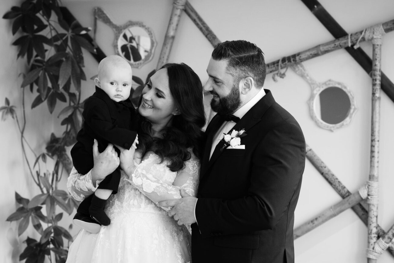 bride and groom and their baby boy in The Barn at Ballymagarvey Village