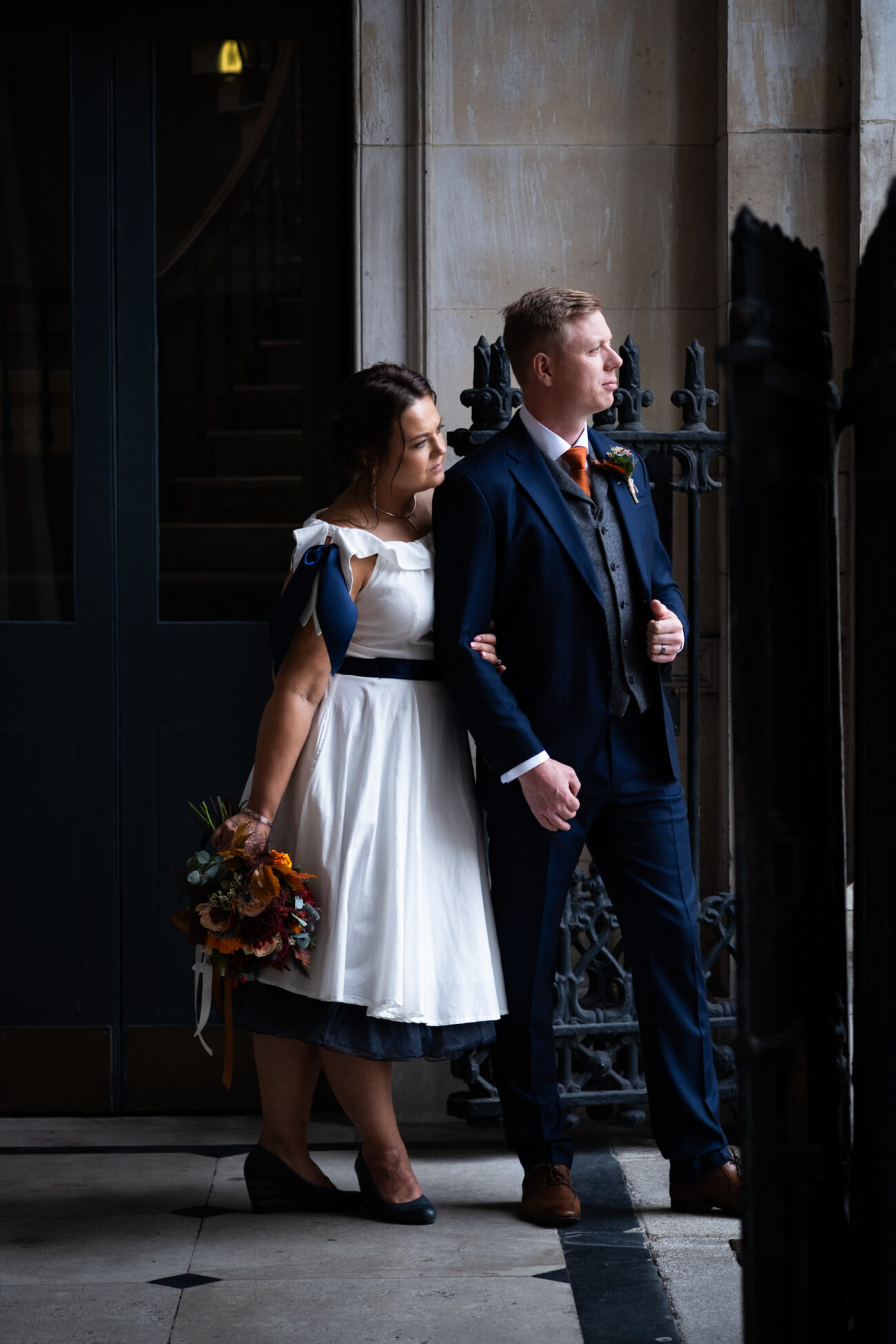 bride and groom looking out into the light at the balcony of Dublin city hall