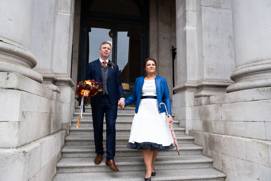 couple walking down the front steps of Dublin City hall, holding hands