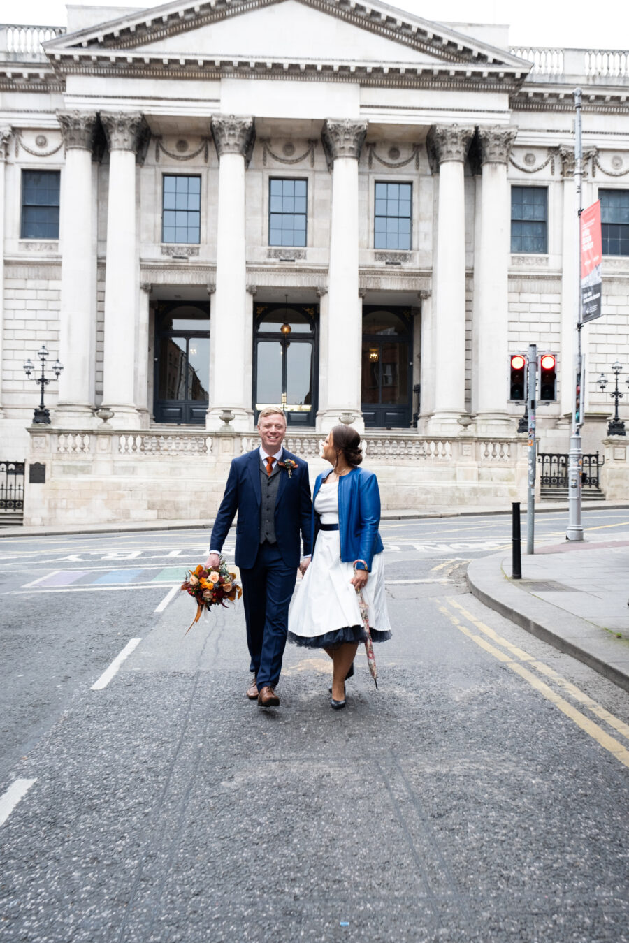 couple walking down Parliament Street with Dublin City Hall in the background