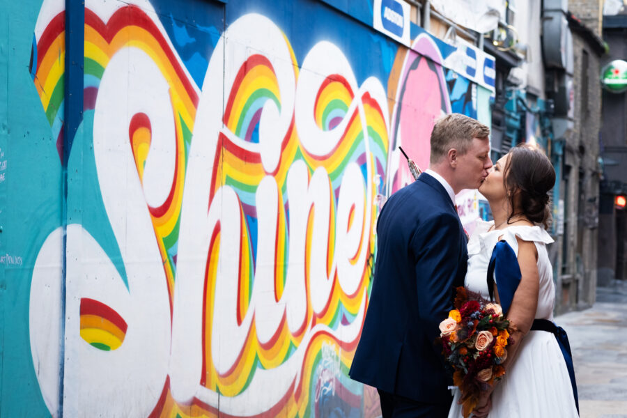 couple kissing in front of 'shine' graffiti wall in Dame lane, Dublin