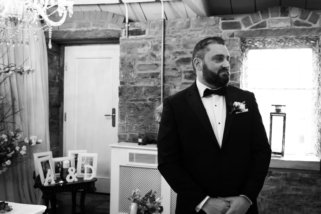 Groom looking at his bride walking down the aisle at Ballymagavery Village wedding.