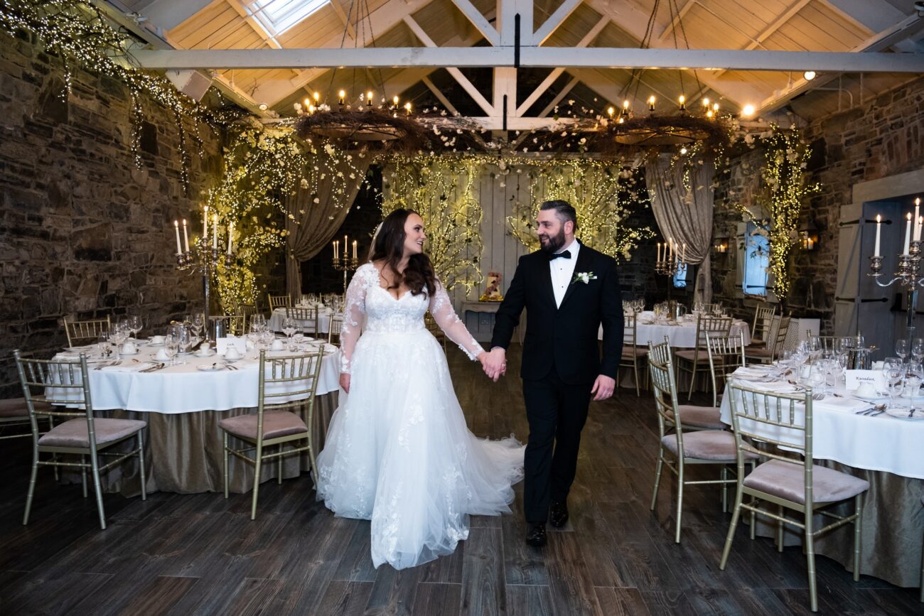 bride and groom walking through the banqueting hall at Ballymagarvey Village