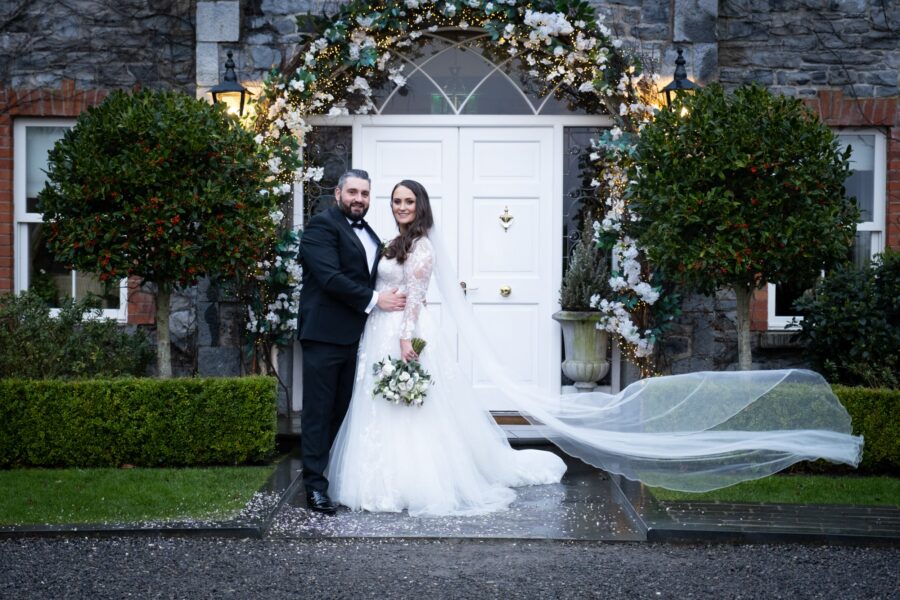 Bride and groom posing at the front of Ballymagarvey Village