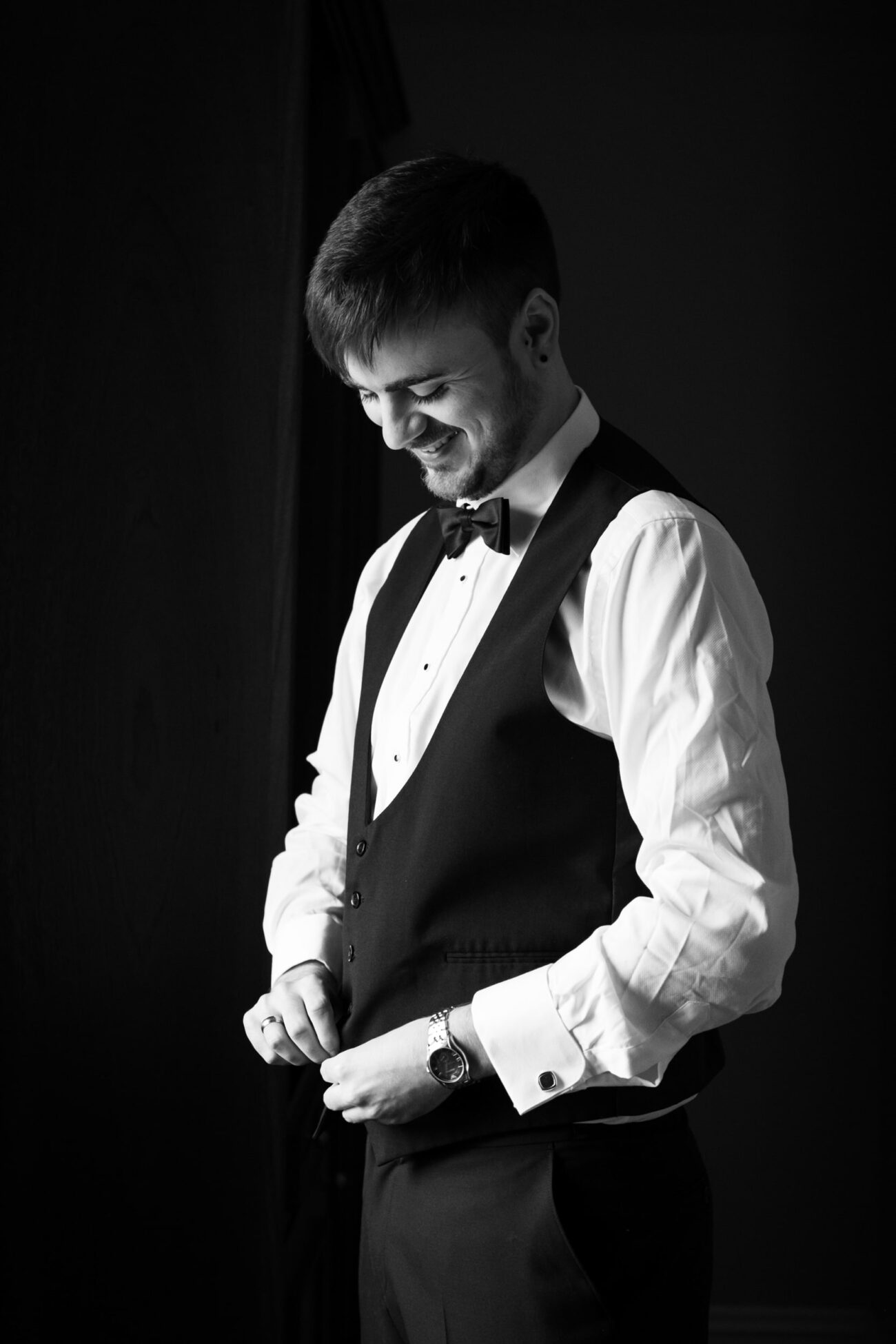 Groom buttoning his waist coat during groom prep at Killashee Hotel