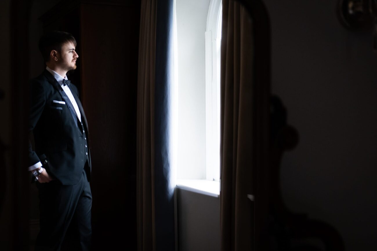 Groom looking out the window at Killashee Hotel