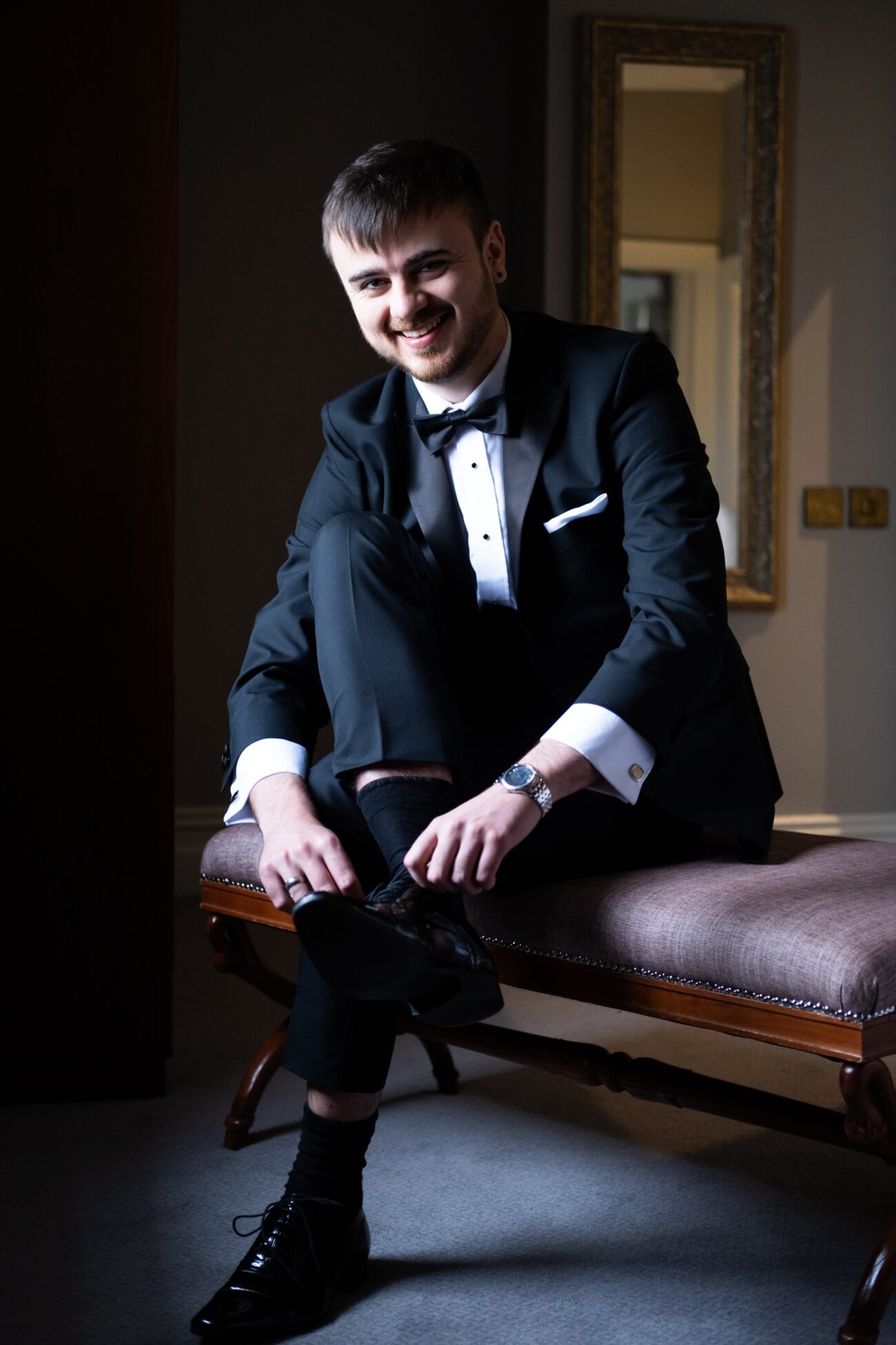 Groom tieing his shoes during groom prep at Killashee Hotel wedding