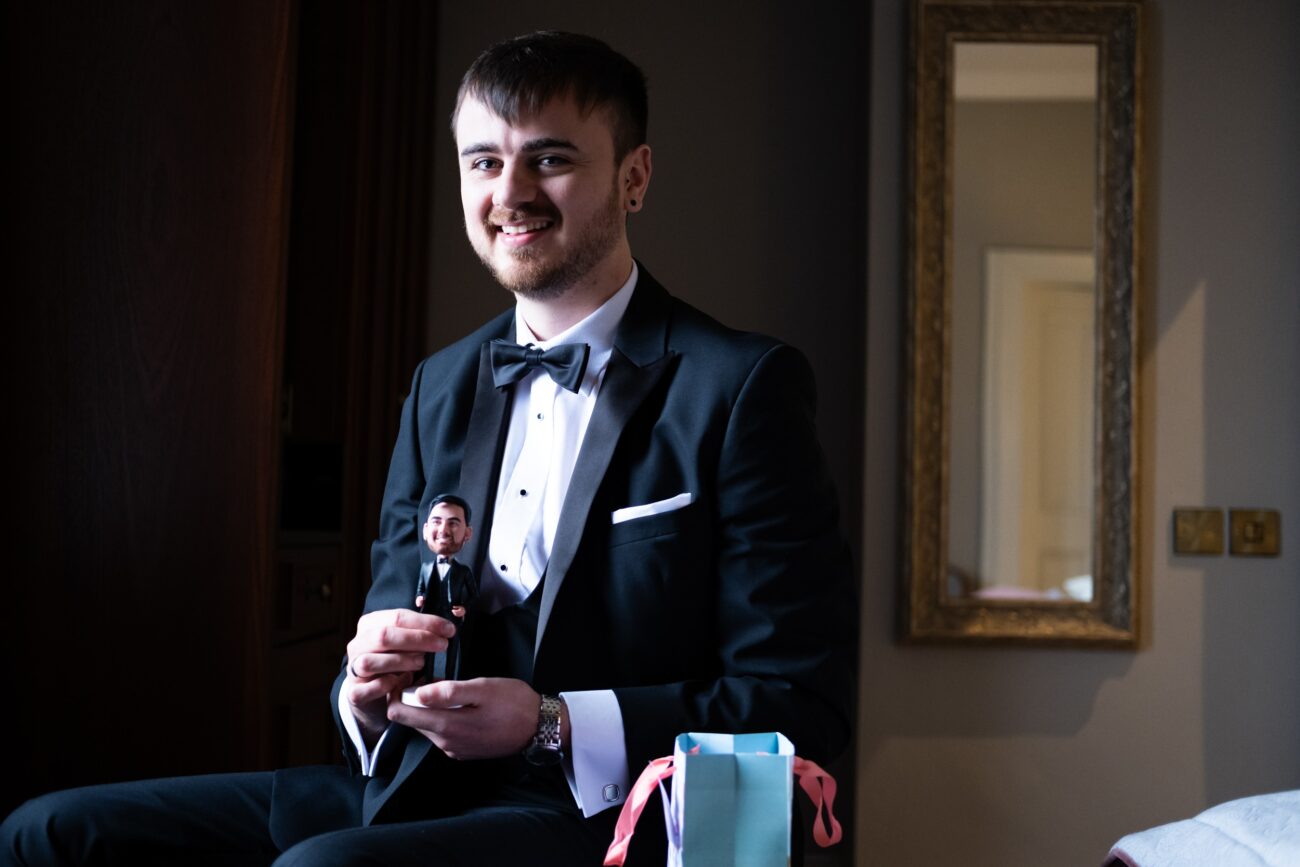 Groom holding his gift during groom prep at Killahsee Hotel