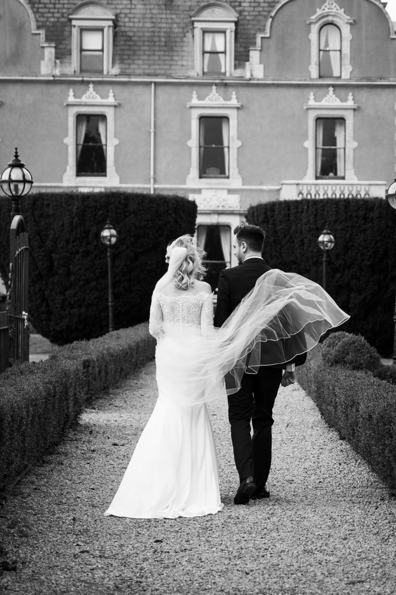 Bride and groom walking towards the old house in the gardens of Killashee Hotel, KIllashee Hotel wedding